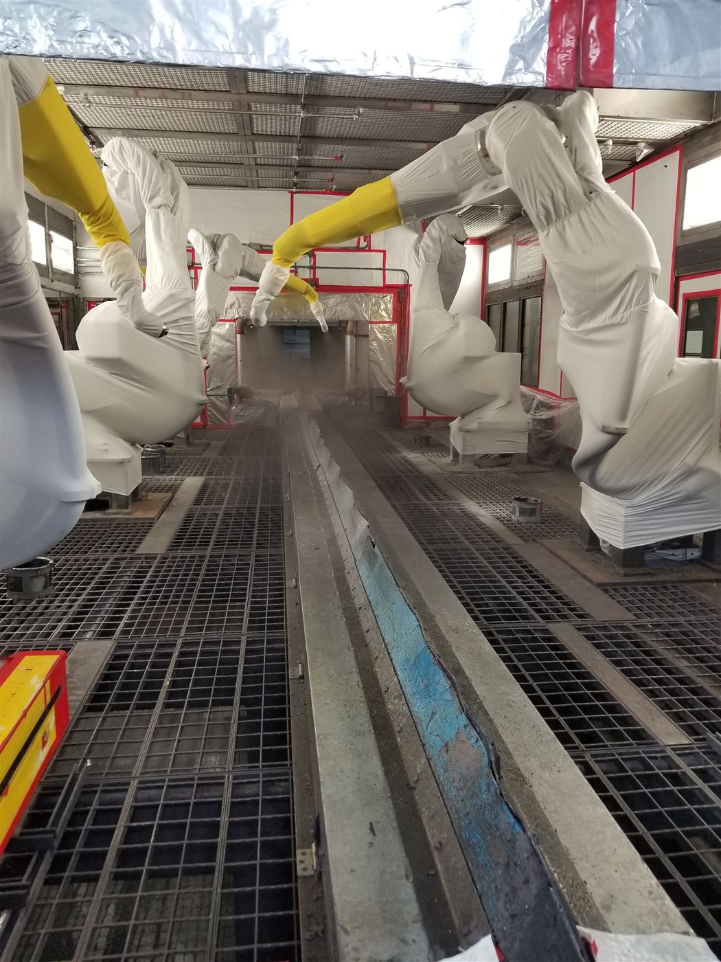 Paint booth with covered robots during a spray trial